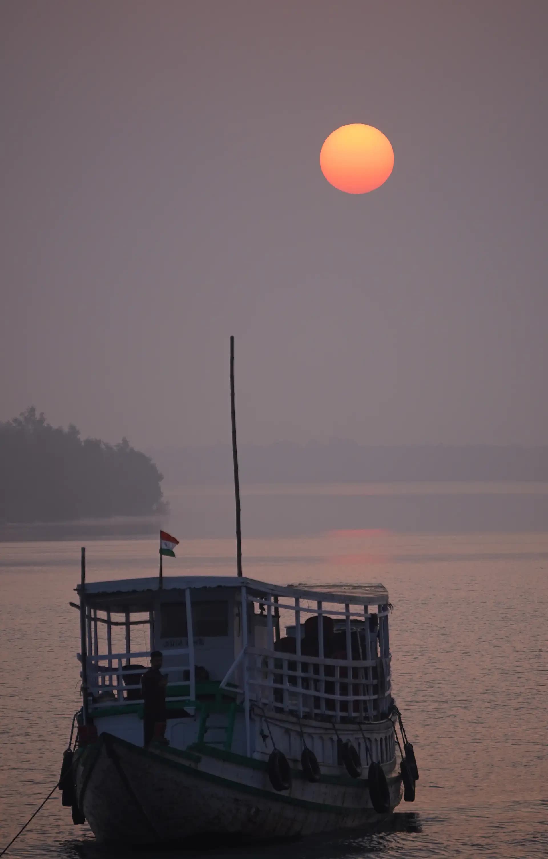 The boat was floating still in the morning under the sun.